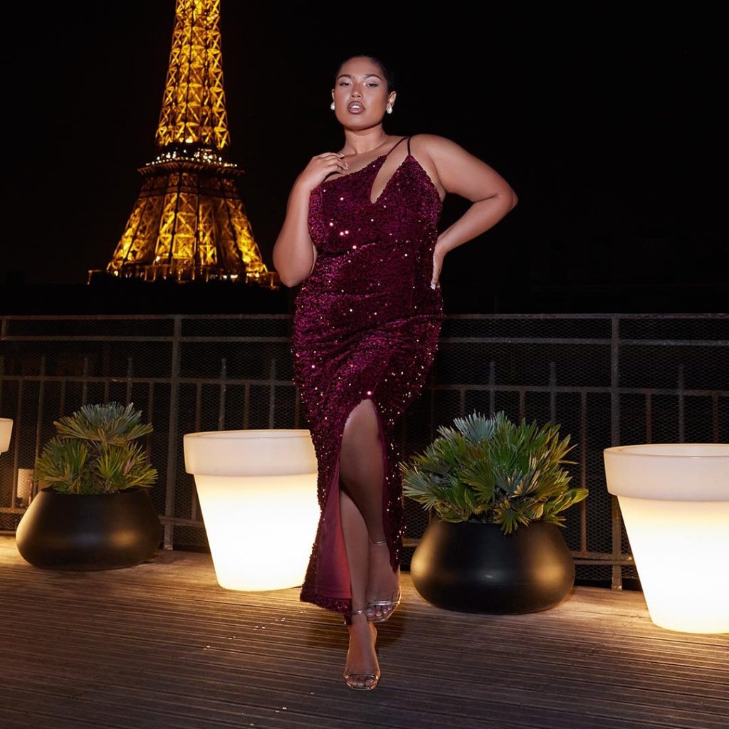 Plus size model posing with eiffel tower back drop